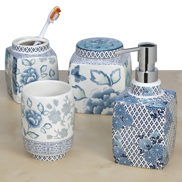 Blue and white 4 piece ceramic bathroom accessory set.  Includes: one toothbrush/toothpaste holder, one tumbler, one whatnot dish and one lotion dispenser.  The design is blue and white flowers and a blue and white diamond shape design on all four pieces, but more on the lotion dispenser.