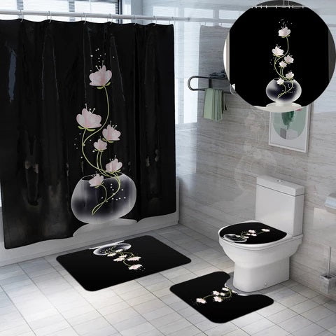 Black Shower Curtain Set.  The sets design is a clear round vase with light pink and white flowers coming out of the vase.  The set includes:  a shower curtain, white shower curtain rings, toilet seat cover, mat for toilet and mat for tub or sink.